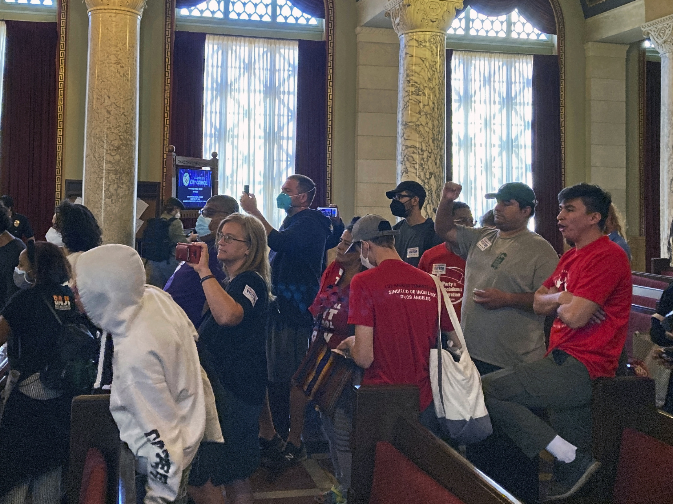caption: Protesters walk away after disrupting a Los Angeles City Council meeting demanding the resignations of council members, Kevin de Leon and Gil Cedillo in Los Angeles, Wednesday, Oct. 26, 2022.