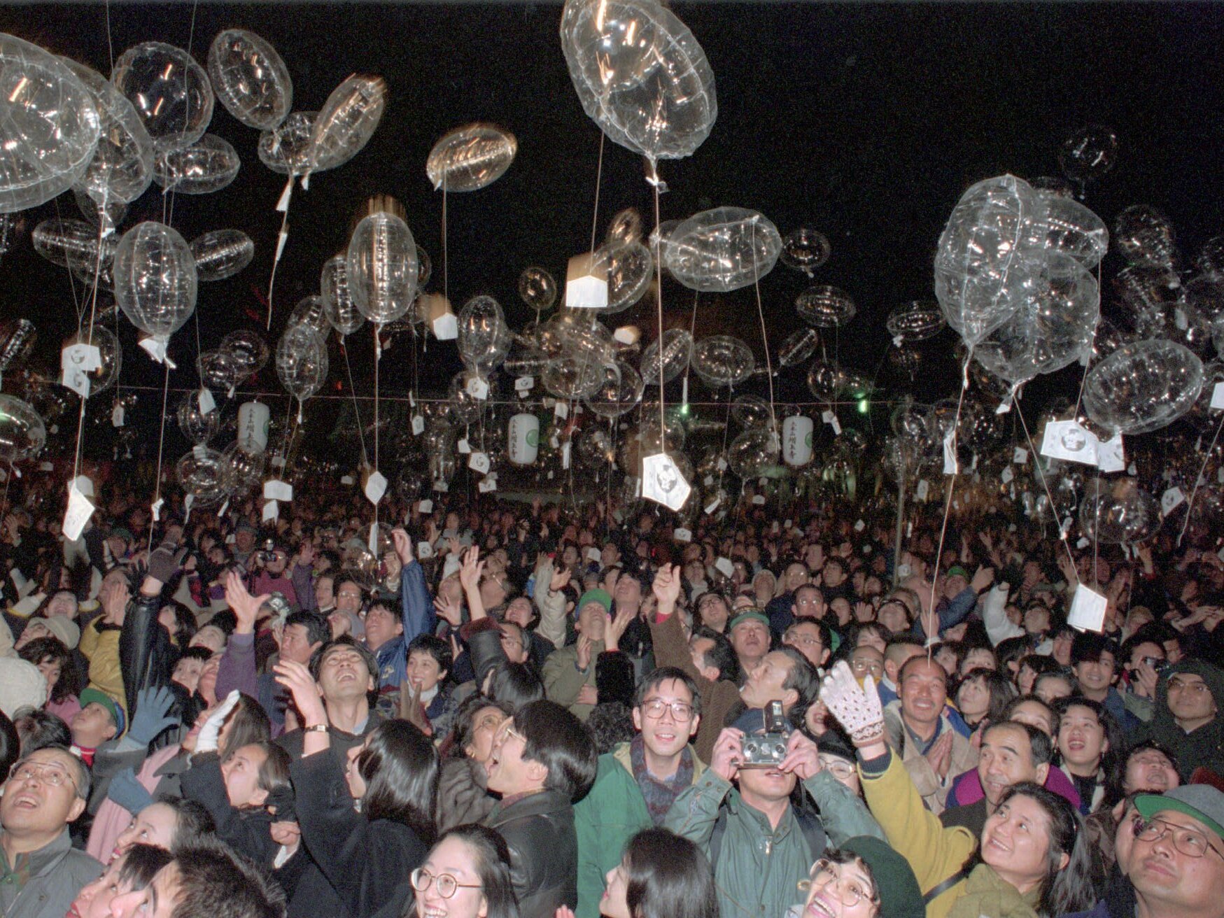 caption: Revelers release New Year's resolutions attached to balloons at Tokyo's Zojoji Temple at the strike of midnight on Jan. 1, 1996.