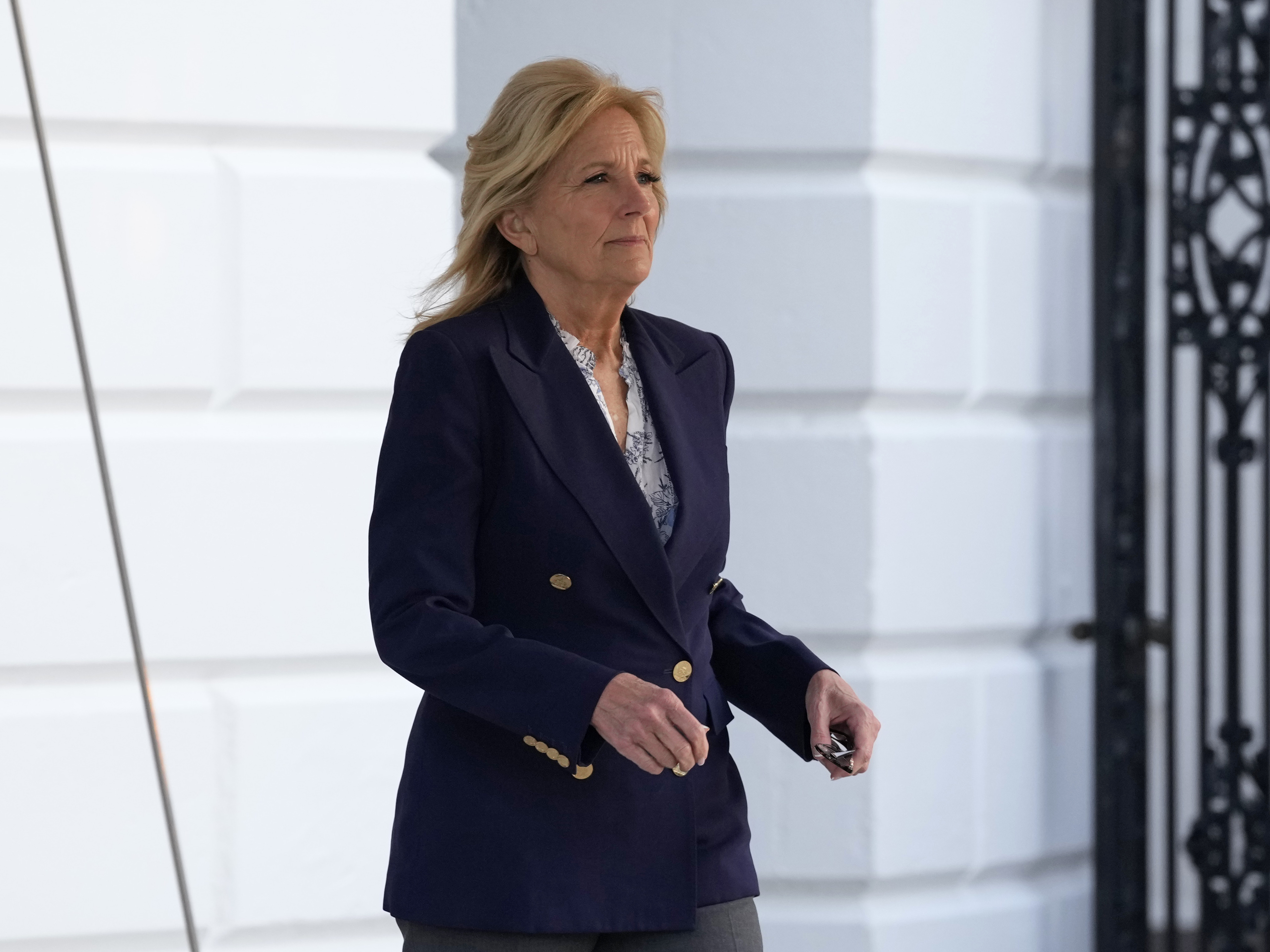 caption: First lady Jill Biden walks out of the White House on Jan. 11. She is having surgery to remove a small lesion found above her right eye during a routine skin cancer screening.