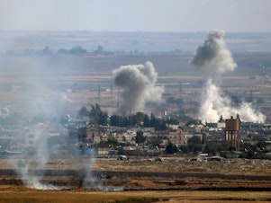 caption: A photo taken from Turkey's Sanliurfa province shows smoke rising after Turkish Armed Forces hit targets in Rasulayn, a town east of the Euphrates River in northern Syria, on Monday.