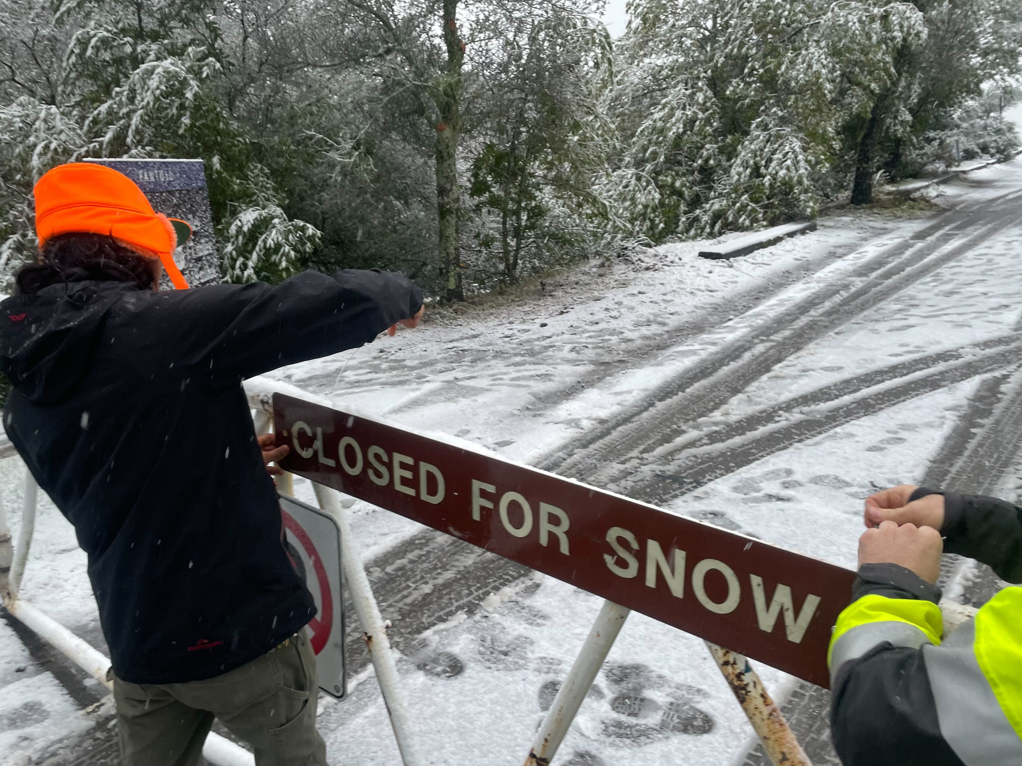 caption: A parks worker puts up a closed sign at the entrance to Mount Tamalpais State Park in Mill Valley, Calif., on Friday. California and other parts of the West are facing heavy snow and rain from the latest winter storm to pound the United States. The National Weather Service has issued blizzard warnings for the Sierra Nevada and Southern California mountains.