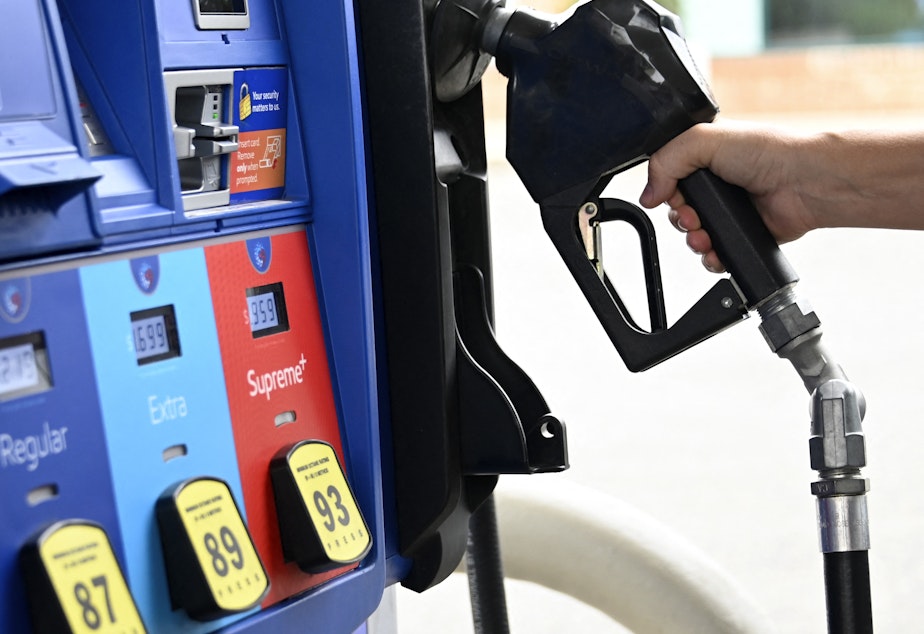 caption: A person goes to the pump at a gas station in Arlington, Va., on July 29. The national average price of gasoline fell below $4 a gallon on Thursday.