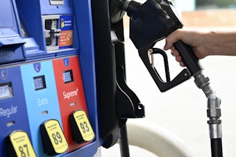 caption: A person goes to the pump at a gas station in Arlington, Va., on July 29. The national average price of gasoline fell below $4 a gallon on Thursday.
