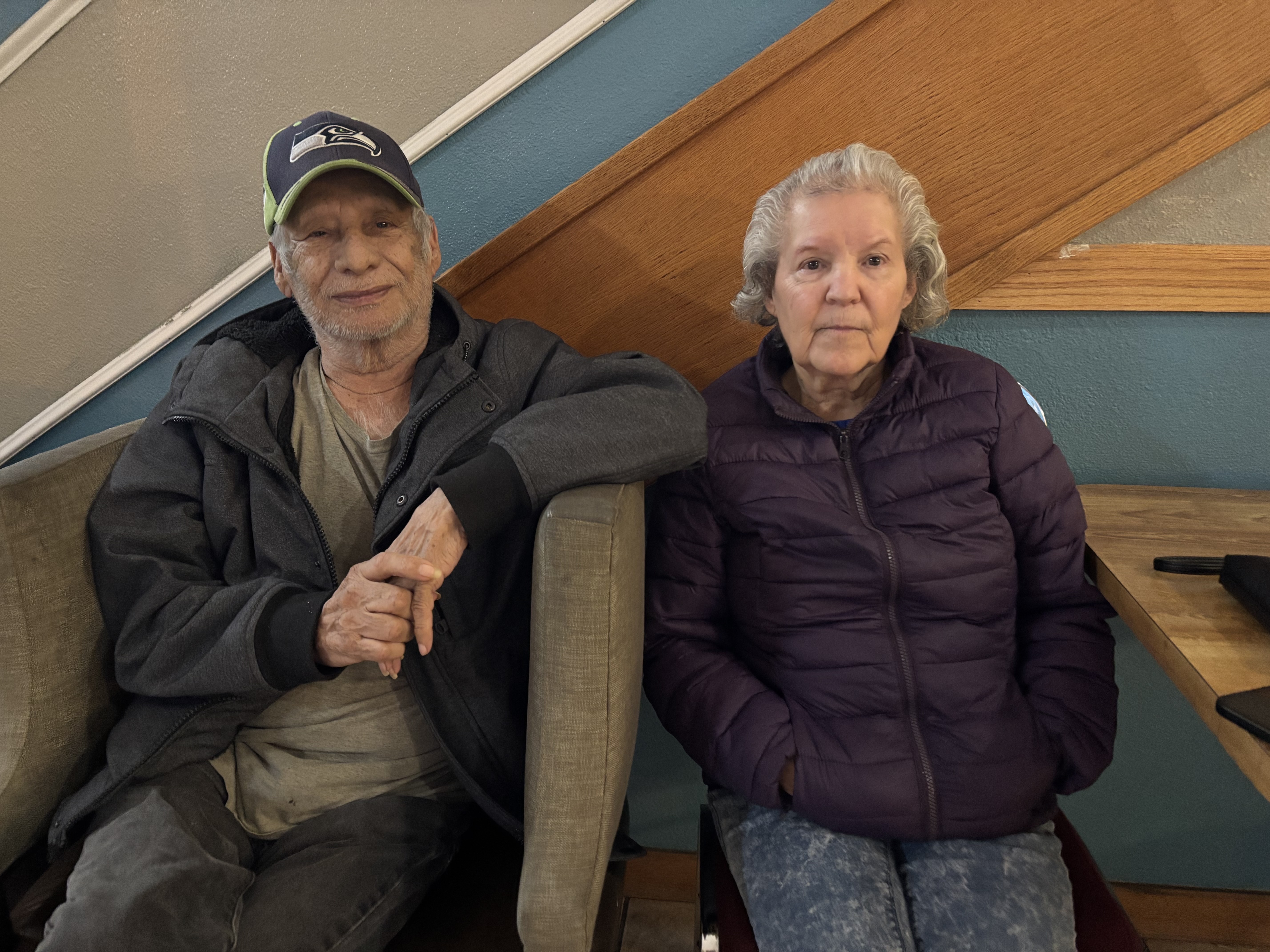 caption: Pedro and Yolanda Cortez sit in the lobby of the Days Inn in Mt. Vernon, preparing for their second night in a hotel on Friday, Dec. 12.