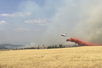 caption: In this photo released by The Eastern Area Incident Management Team, a Very Large Air Tanker (VLAT) drops retardant on a wheat field as crews continue to battle a wildfire in eastern Washington state Sunday, Aug. 5, 2018.