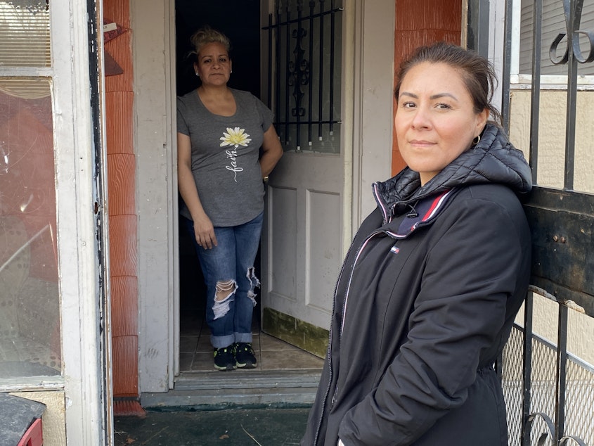 caption: Marisela Orozco (foreground) is letting her sister, Marissa, live in the house she thought she would own after making almost four years of payments. But the owner disappeared, along with the title, and she worries he may return and evict them.