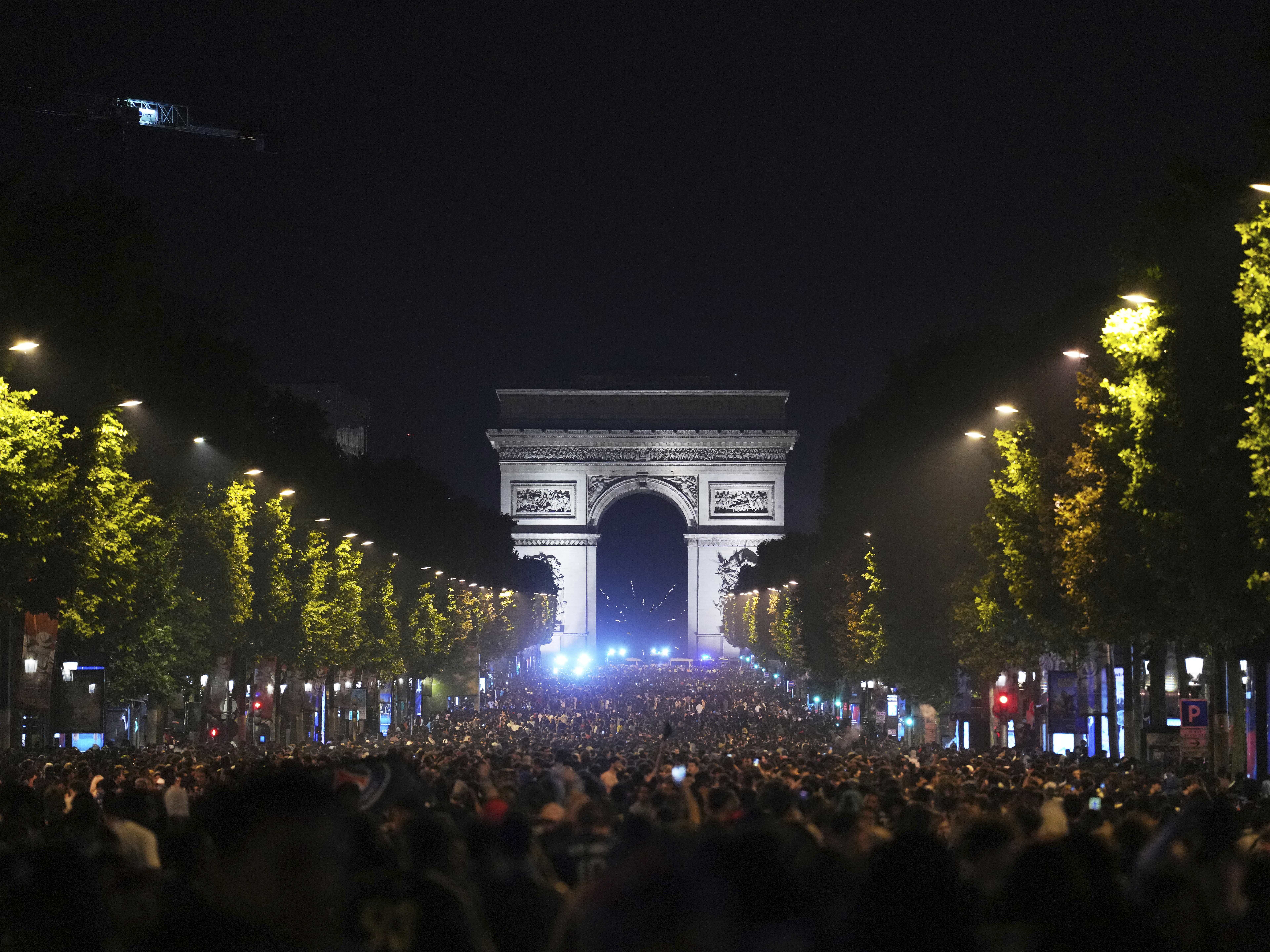 caption: Soccer fans celebrate PSG's victory on the Champs-Elysees avenue, with the Arc de Triomphe in background, after the Champions League final soccer match between Paris Saint-Germain and Inter Milan, Sunday, June 1, 2025 in Paris.