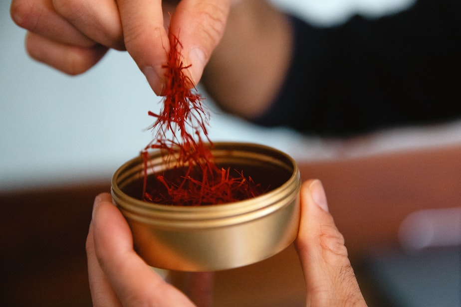 caption: Chef and cookbook author Omid Roustaei holds saffron threads on Wednesday, April 23, 2025, at The Pantry in the Ballard neighborhood of Seattle.