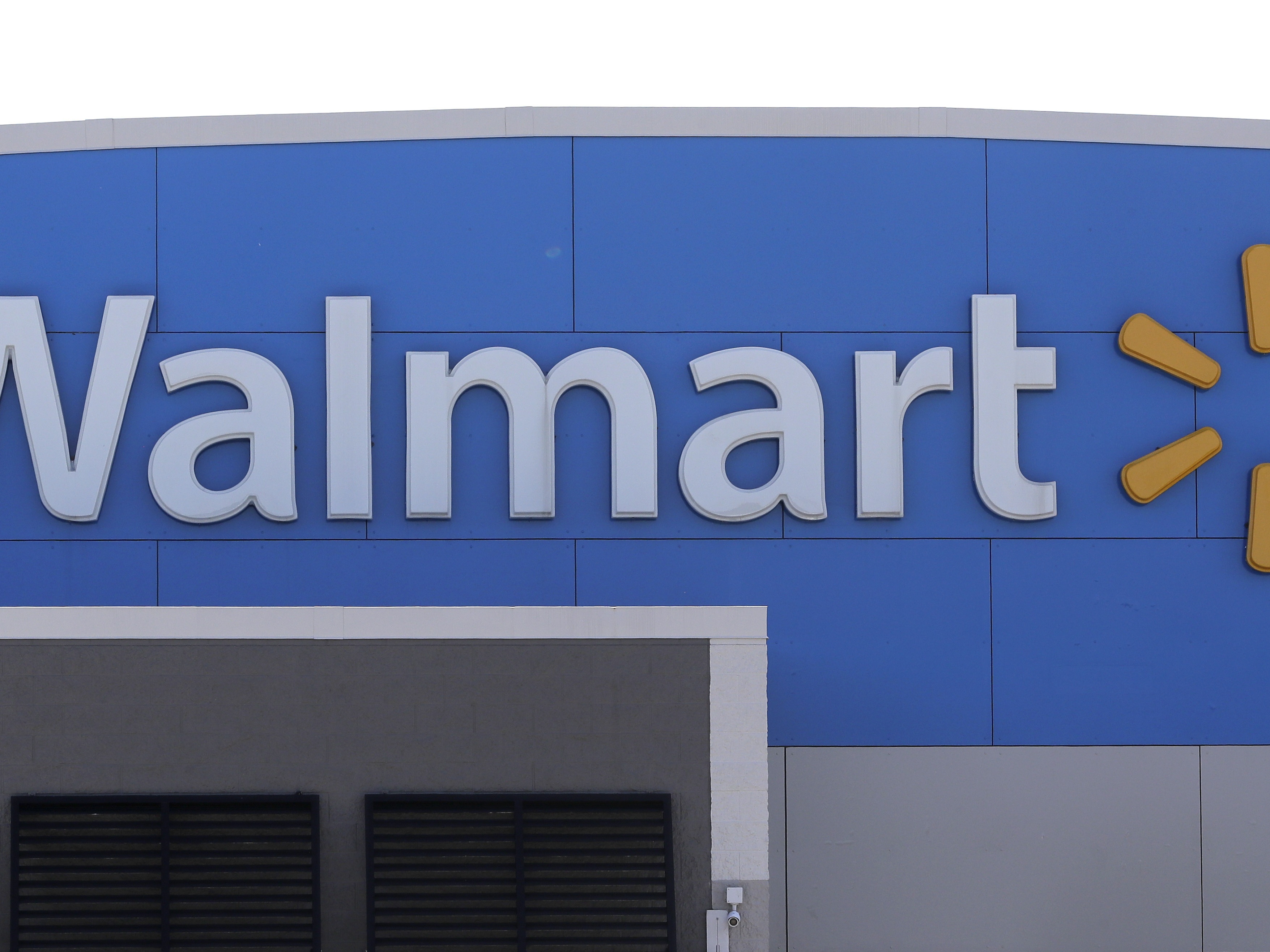 caption: A Walmart logo is displayed outside of a Walmart store in Walpole, Mass.