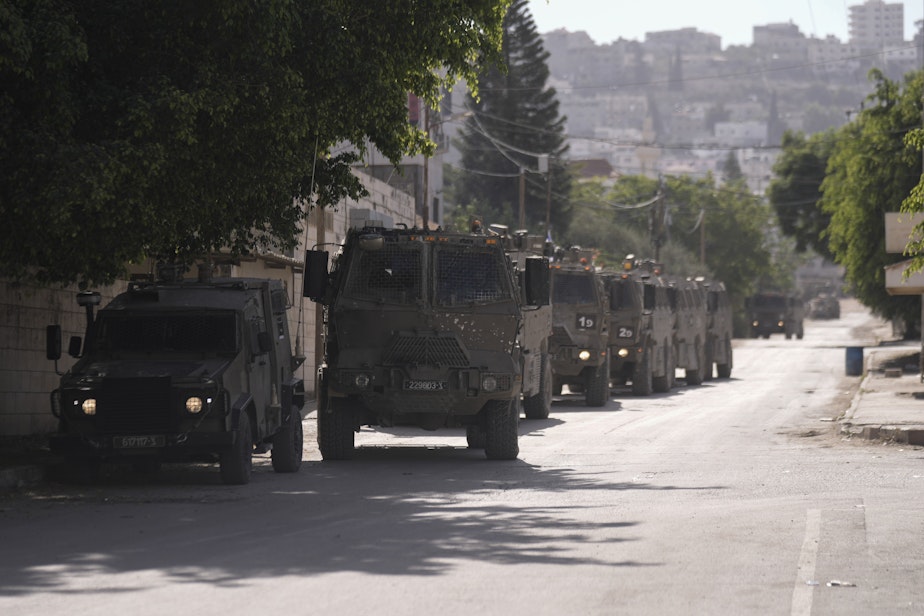 caption: Israeli military convoy enters the Palestinian refugee camp in Jenin, the West Bank, Thursday, Nov. 9, 2023.