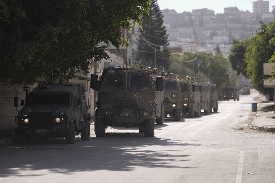 caption: Israeli military convoy enters the Palestinian refugee camp in Jenin, the West Bank, Thursday, Nov. 9, 2023.