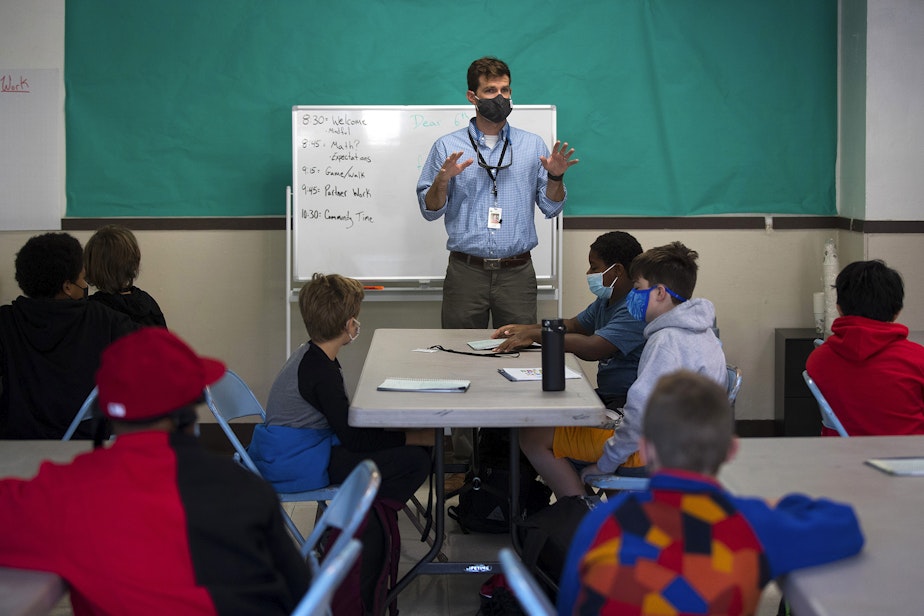 caption: Seattle School for Boys 6th-grade teacher Buck McKenna welcomes students back to the classroom on the first day of school, Monday, September 13, 2021, in Seattle. 