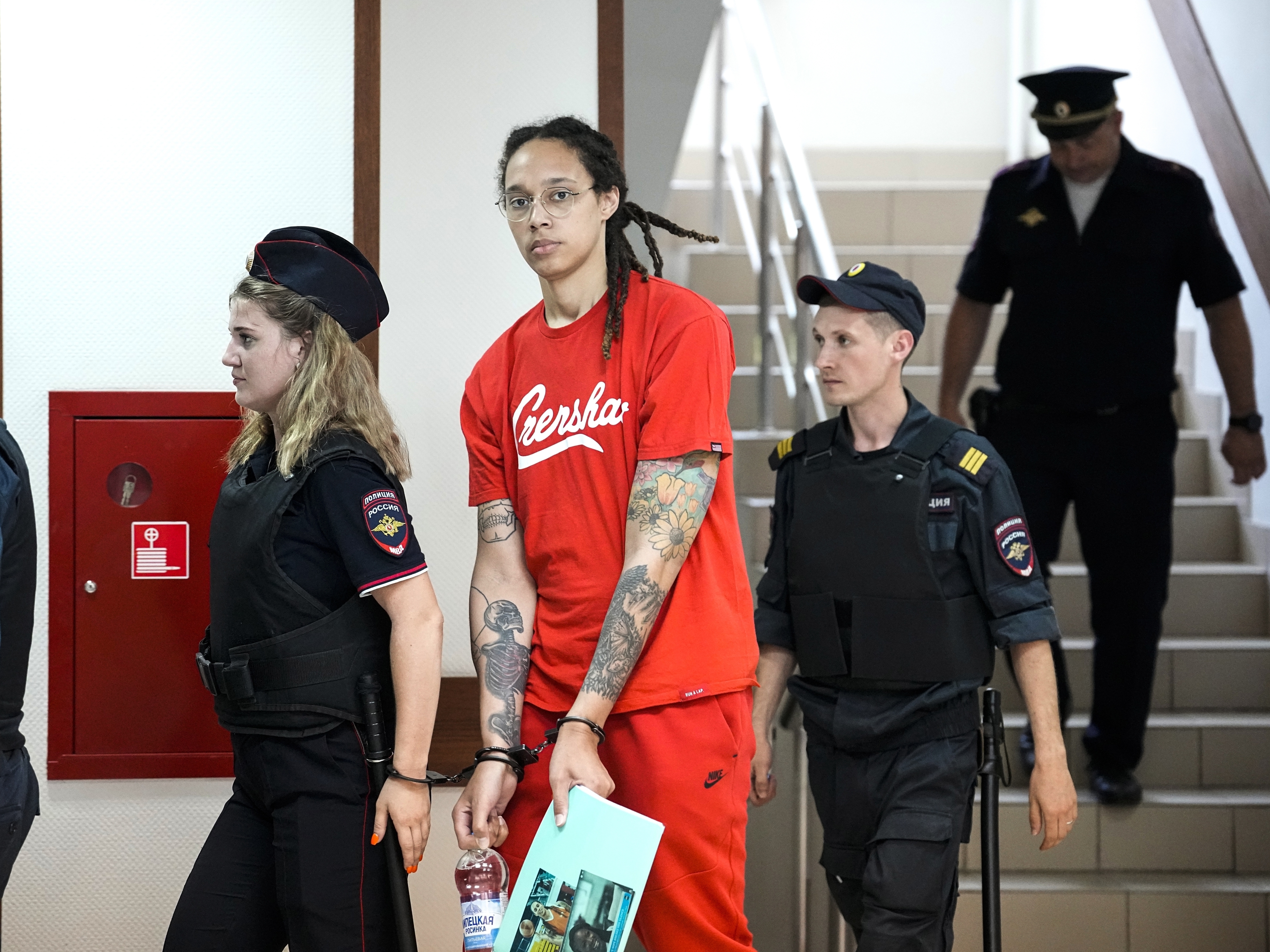 caption: Brittney Griner is escorted to a courtroom in Khimki, just outside Moscow, for a hearing on Thursday.