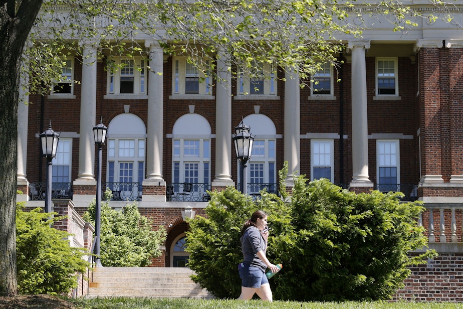 caption: In this photo taken on Wednesday, May 13, 2015, a Sweet Briar College student walks past a building at the school in Sweet Briar, Va. The school nearly closed in 2015 amid financial difficulties. (Steve Helber/AP)