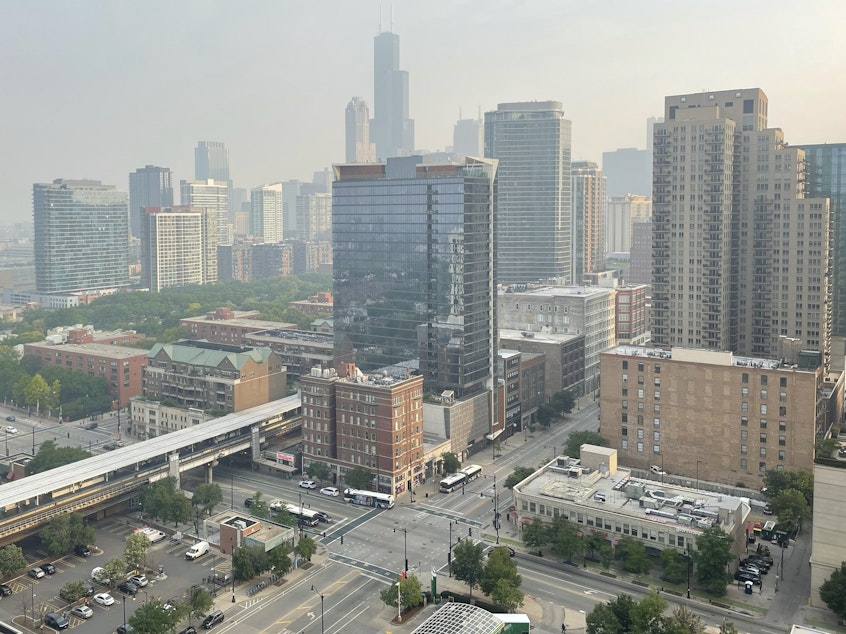 caption: Haze from Canadian wildfires blankets the Chicago skyline as seen from the city's South Loop neighborhood on Wednesday.