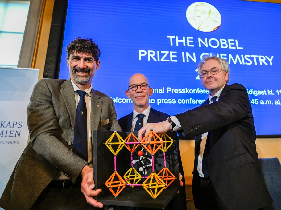 caption: From left, Chair of the Nobel Committee for Chemistry Heiner Linke, Secretary General of the Swedish Academy of Sciences Hans Ellegren, and Member of the Nobel Committee for Chemistry Olof Ramstrom pose Wednesday after announcing Susumu Kitagawa, Richard Robson and Omar Yaghi as the recipients the Nobel Prize in Chemistry, at the Nobel Assembly of the Karolinska Institutet, in Stockholm, Sweden.