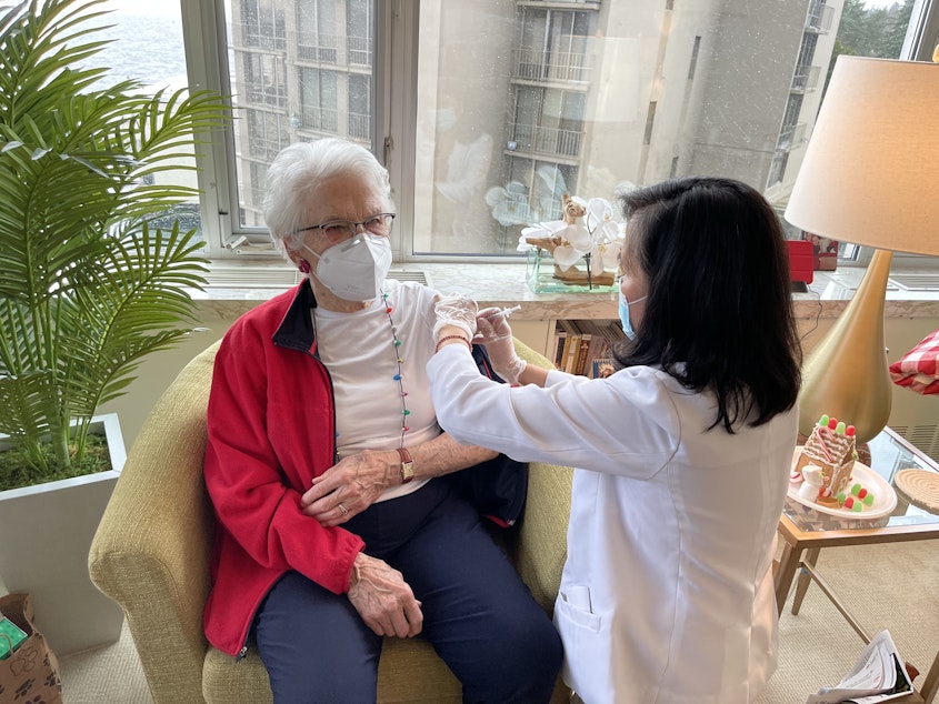 caption: Flor Craig (r) injects Parkshore resident Lovie Therriault with her first dose of the Pfizer-BioNTech Covid vaccine, December 21, 2020. 