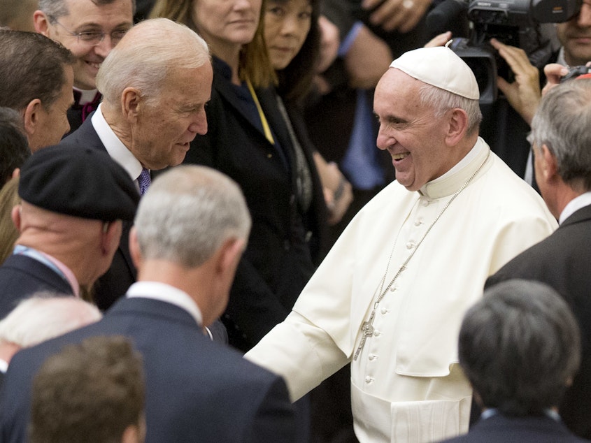 caption: Pope Francis shakes hands with Joe Biden, then vice president, at the Vatican, in 2016.