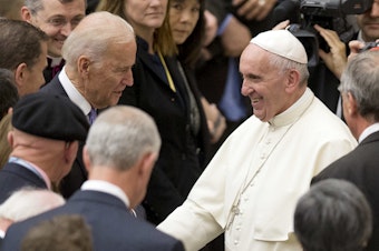 caption: Pope Francis shakes hands with Joe Biden, then vice president, at the Vatican, in 2016.