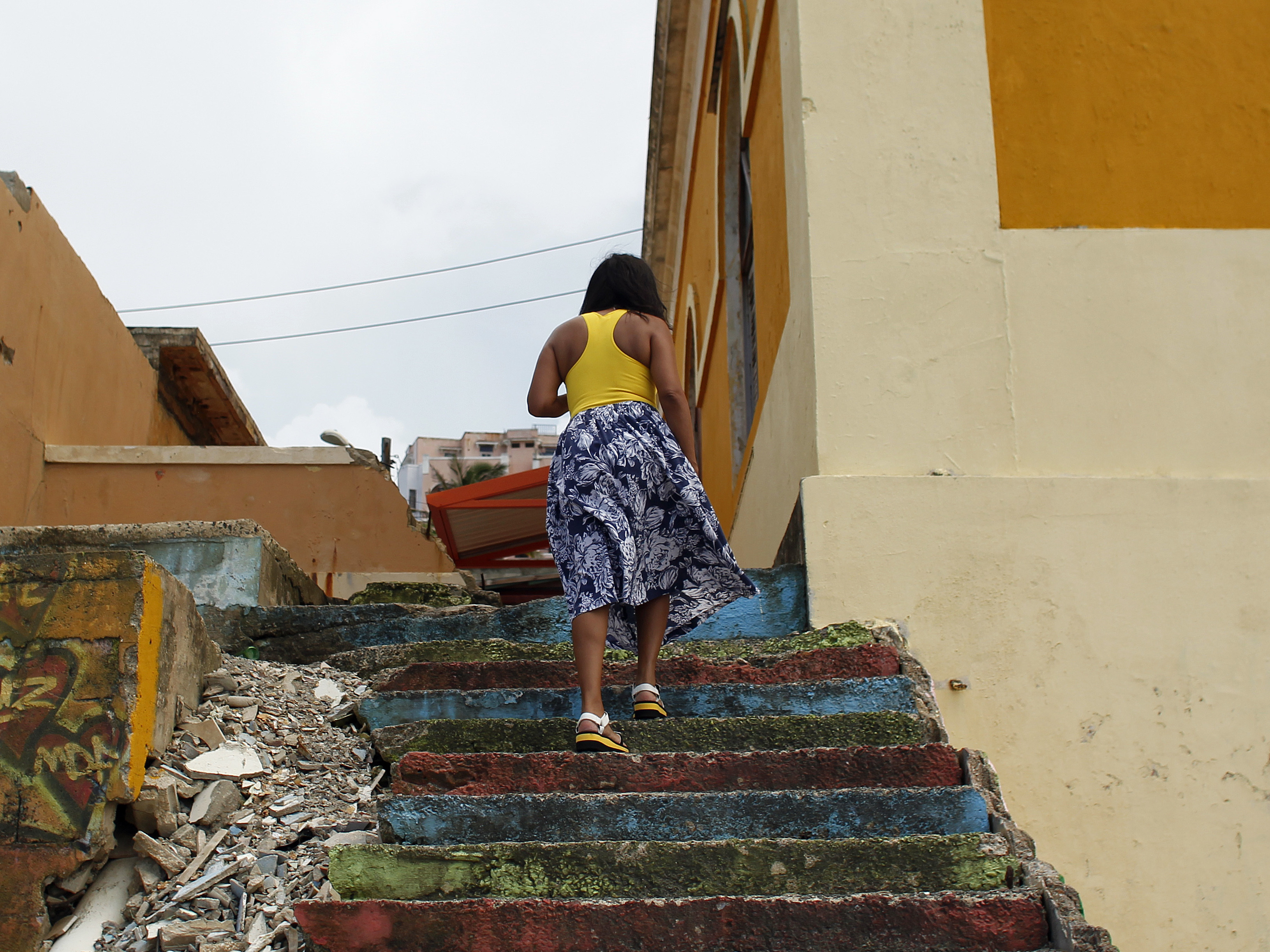 caption: A woman walks through La Perla, a neighborhood on the edge of Old San Juan, in 2017.