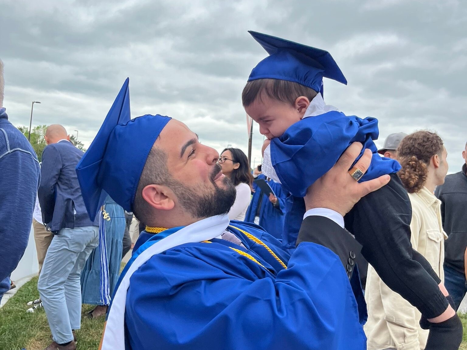 caption: Jean Paul Al Arab and his son, 6-month-old Mtanos, celebrate the elder Al Arab's graduation from the University at Buffalo.