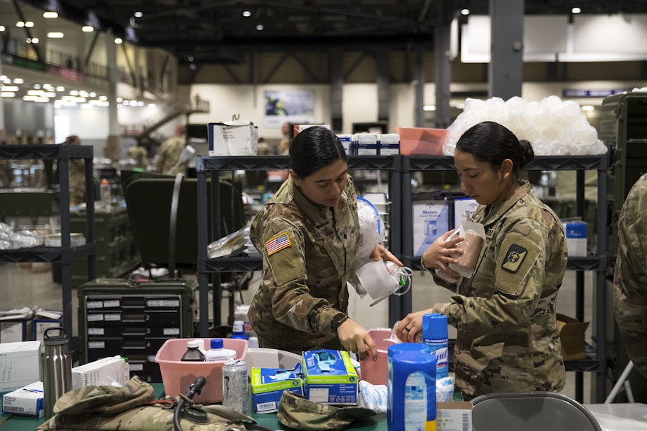 caption: U.S. Army soldiers store medical supplies on Tuesday, March 31, 2020, at the 250-bed military field hospital for non COVID-19 patients deployed at the CenturyLink Field Event Center in Seattle. 