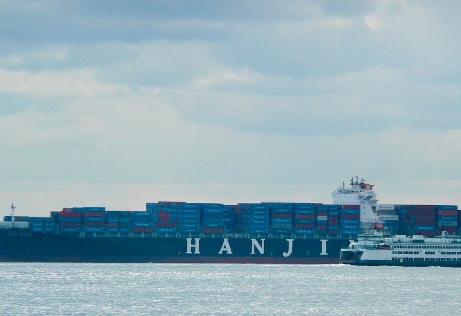 caption: A Hanjin shipping container ship dwarfs a Washington State Ferry.