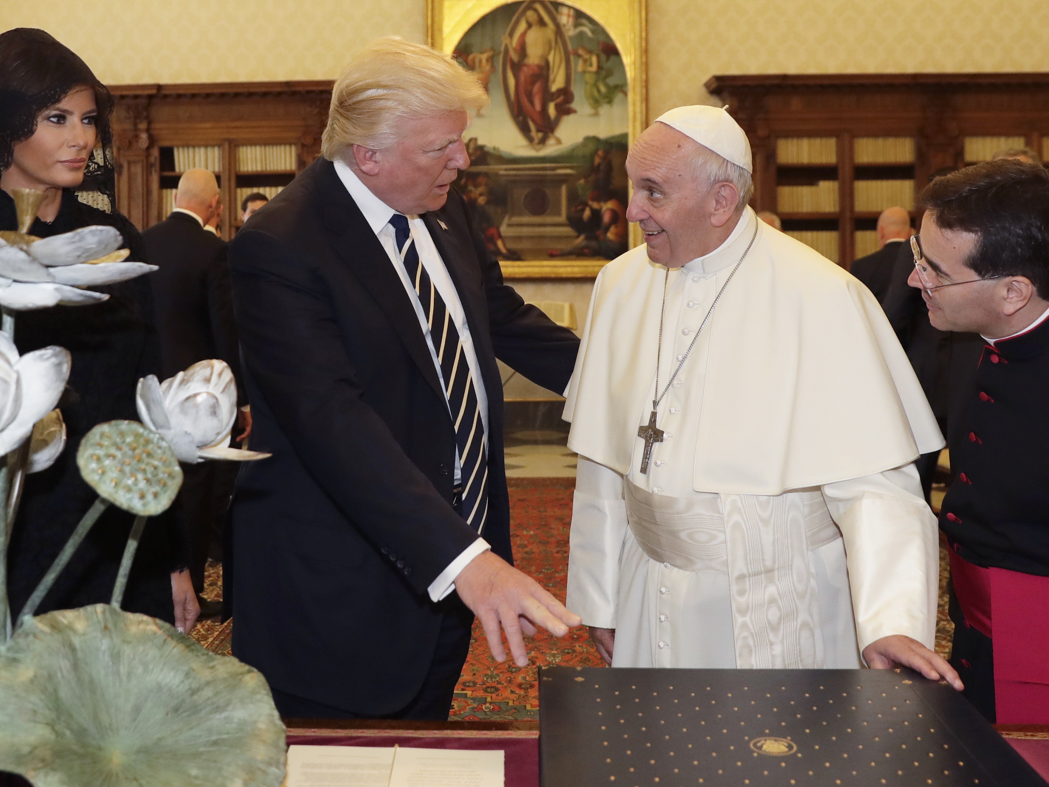 caption: Pope Francis exchanges gifts with US President Donald Trump (C) and US First Lady Melania Trump during a private audience at the Vatican on May 24, 2017. US President Donald Trump met Pope Francis at the Vatican today in a keenly-anticipated first face-to-face encounter between two world leaders who have clashed repeatedly on several issues.