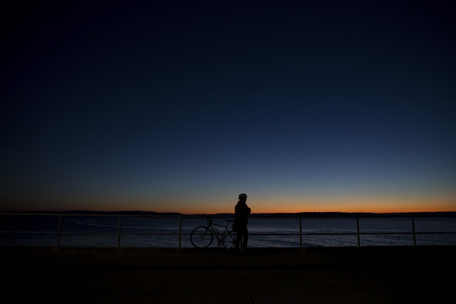 caption: Eric Shalit watches the sunset during a bike ride on Tuesday, December 5, 2017, in West Seattle.