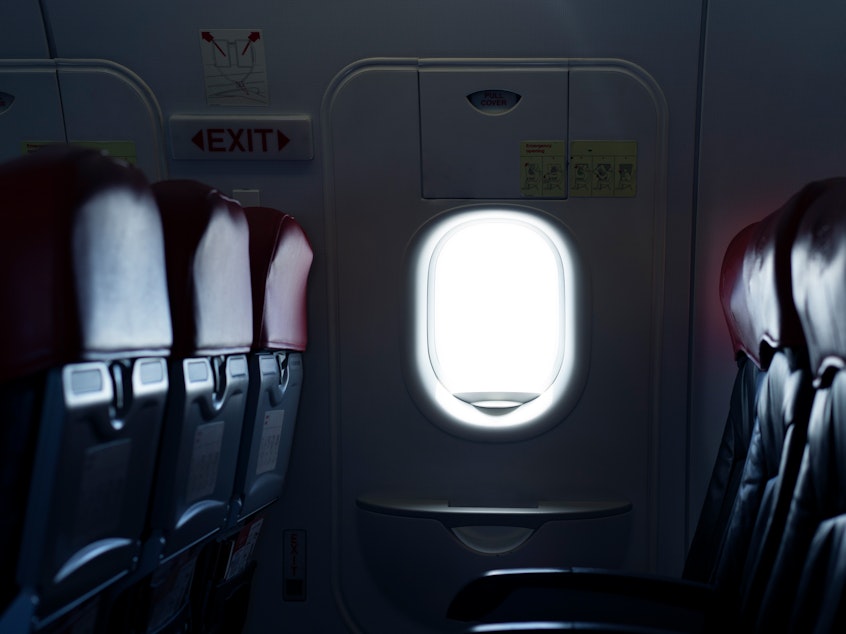caption: Where should you sit on a plane to reduce the risk of exposure to germs spread by infectious passengers?