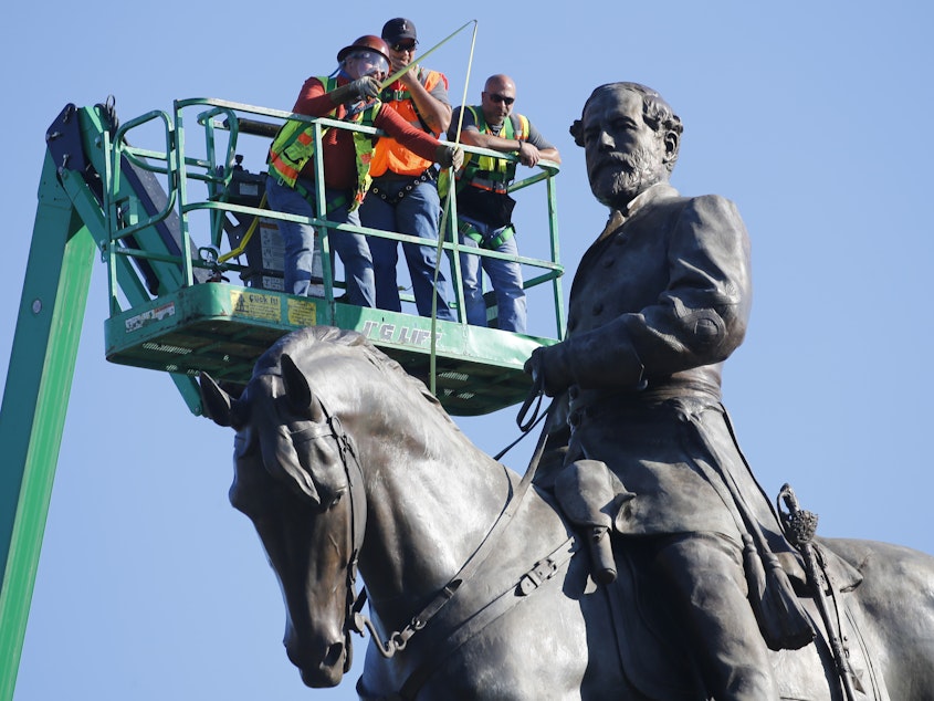 caption: A crew plans the operation to remove the statue of Confederate Gen. Robert E. Lee on Monument Ave. in Richmond, Va.
