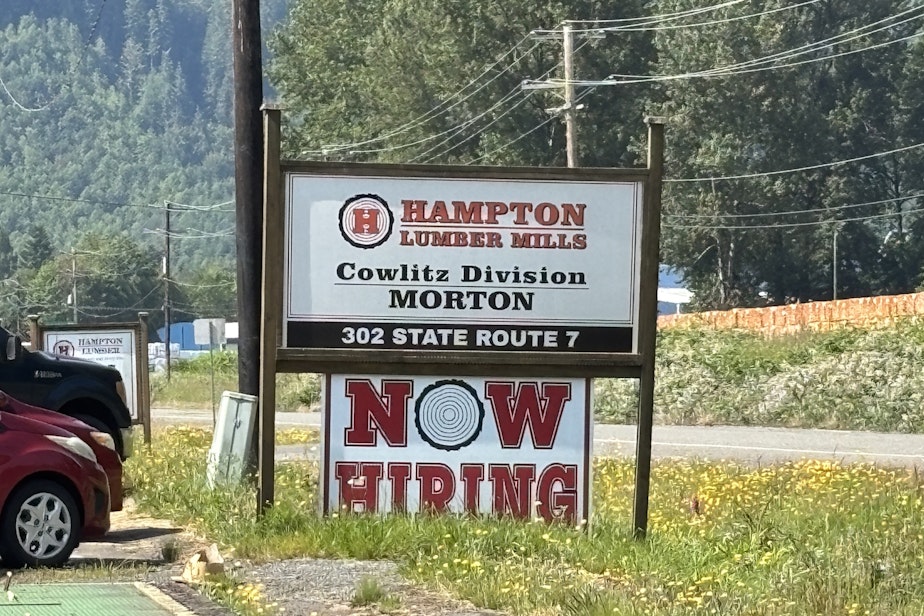 caption: A sign in front of the Hampton Mill says "Now Hiring."