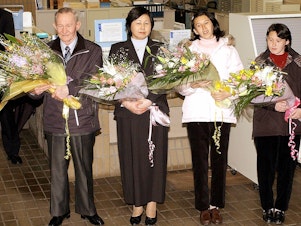 caption: Charles Jenkins (left), age 64, his wife Hitomi Soga (second from left) and their daughters arrive at Japan's Sado Island in December 2004, almost 40 years after he defected to North Korea.