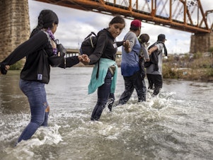 caption: Immigrants from Venezuela crossed the Rio Grande from Mexico into the U.S. last month in Eagle Pass, Texas.