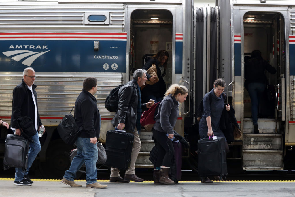 caption: Passengers wait to board an Amtrak train. (Alex Wong/Getty Images)