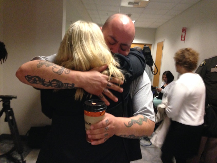 caption: Officer Timothy Brenton's brother and stepmother embrace at the King County Courthouse following the guilty verdict of Christopher Monfort. Monfort was found guilty of mudering Brenton while he was sitting in his patrol car in 2009.