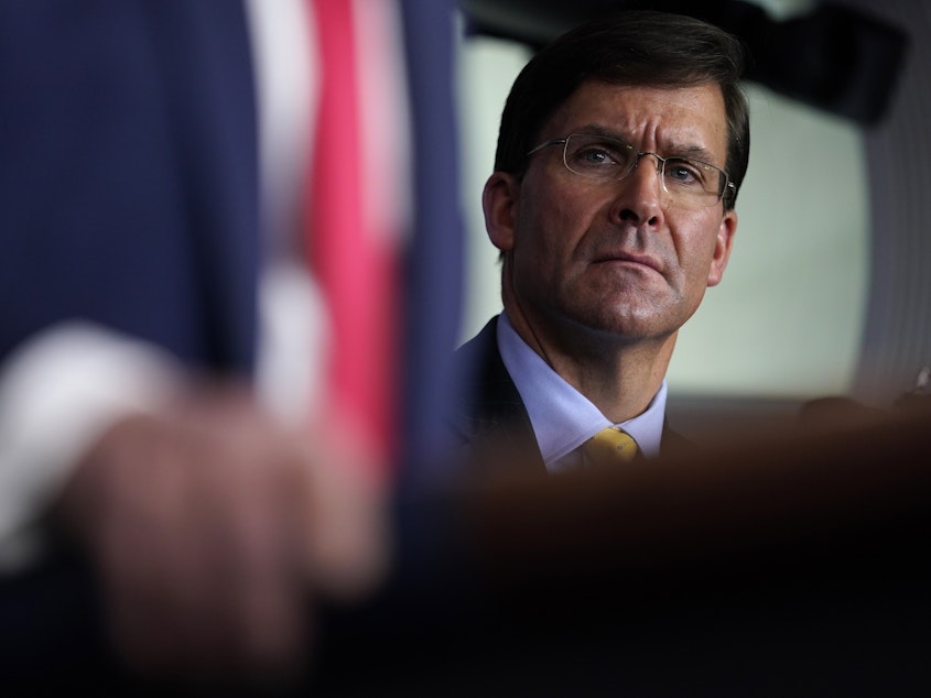 caption: Defense Secretary Mark Esper listens as President Trump speaks during a news briefing with the Coronavirus Task Force at the White House last week.