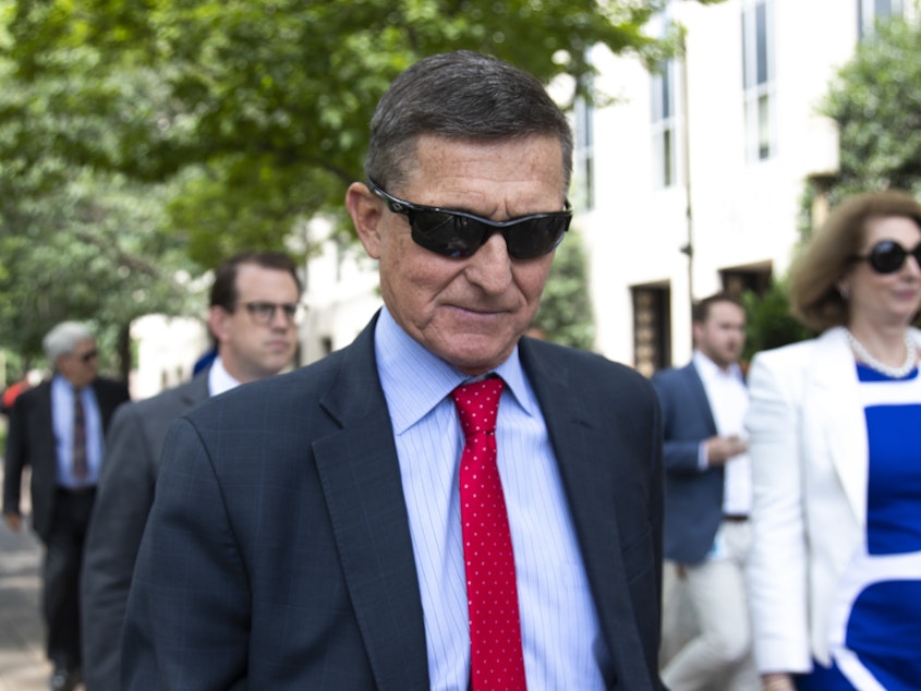 caption: Former National Security Adviser Michael Flynn leaves the federal courthouse in Washington, in June. Flynn's attorneys say newly released documents prove the FBI laid a "perjury trap" for their client.