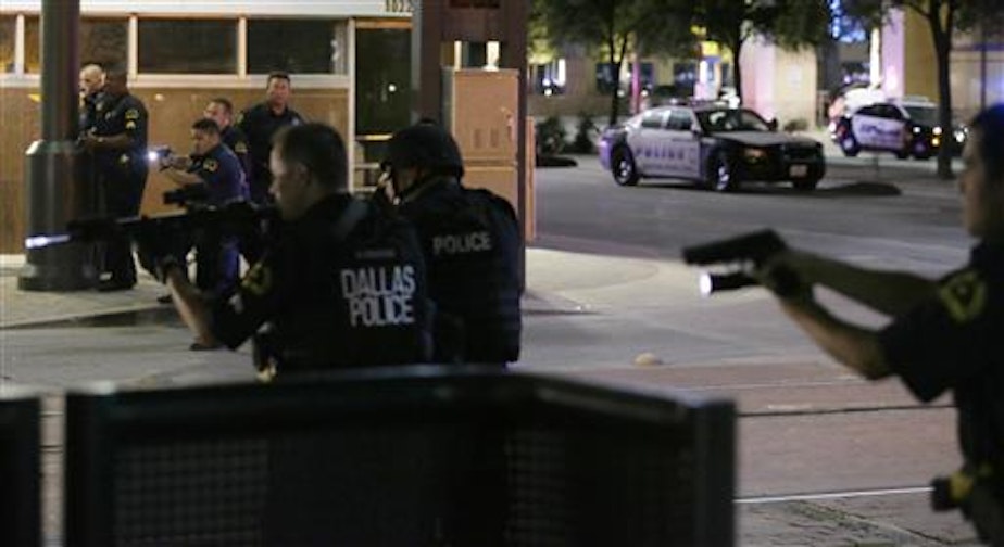 caption: Dallas police detain a driver after several police officers were shot in downtown Dallas, Thursday, July 7, 2016. Snipers apparently shot police officers during protests and some of the officers are dead, the city's police chief said in a statement.