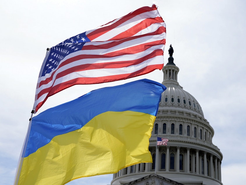 caption: The American and Ukrainian flags wave in the wind outside of the Capitol. The Senate is moving ahead with $95 billion in war aid to Ukraine, Israel and Taiwan.
