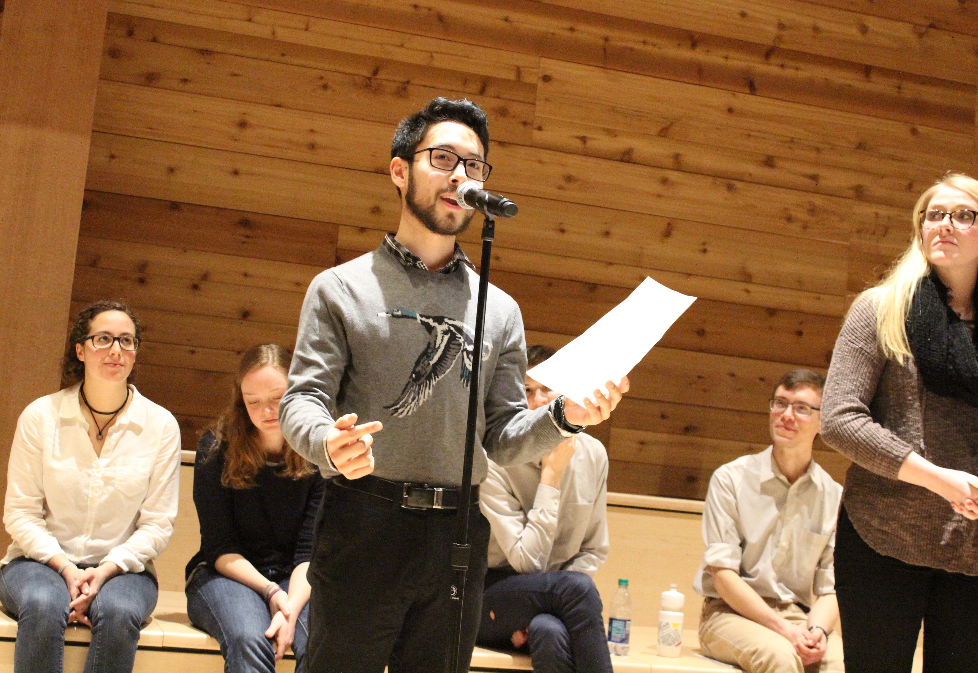 caption: UW student Mack Ikeru reading stories from the Vulnerability Collective