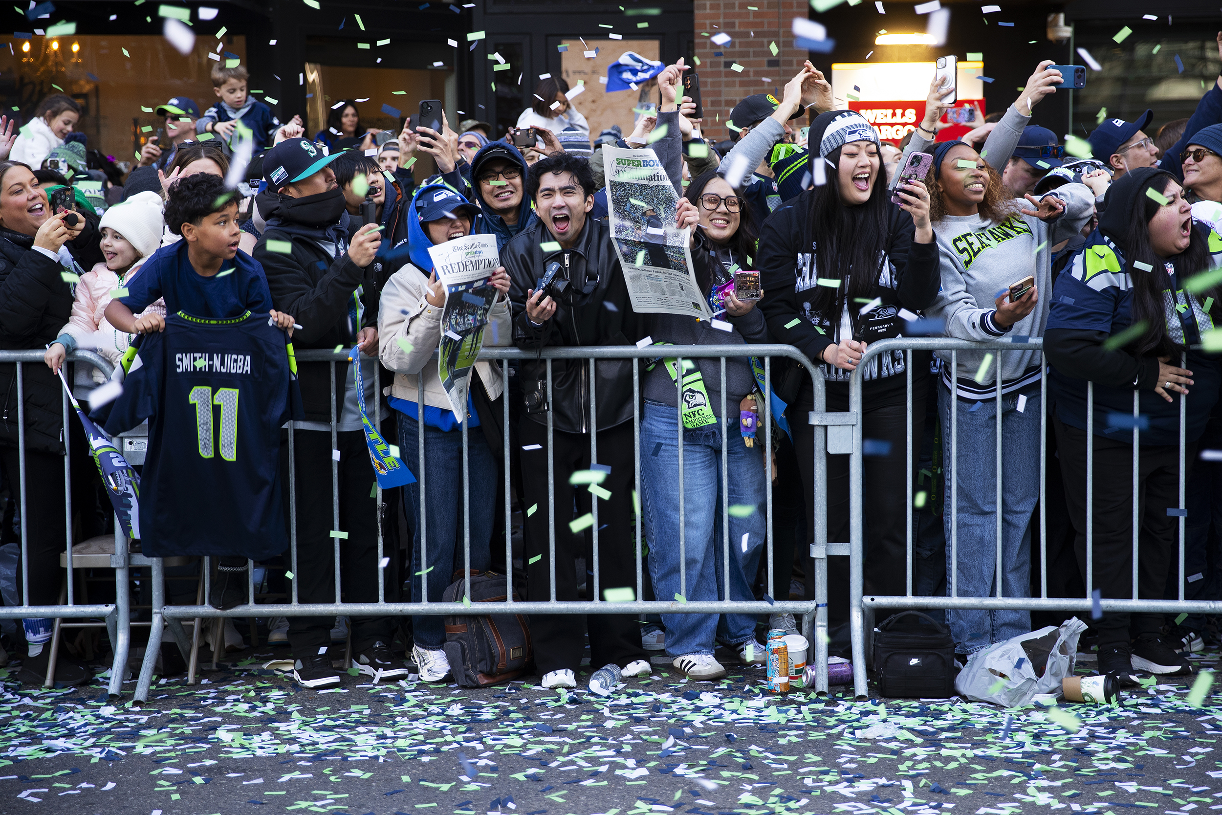 caption: Seahawks fans cheer as team members pass them by during the Seahawks parade on Wednesday, February 11, 2026, along 4th Avenue in Seattle. 