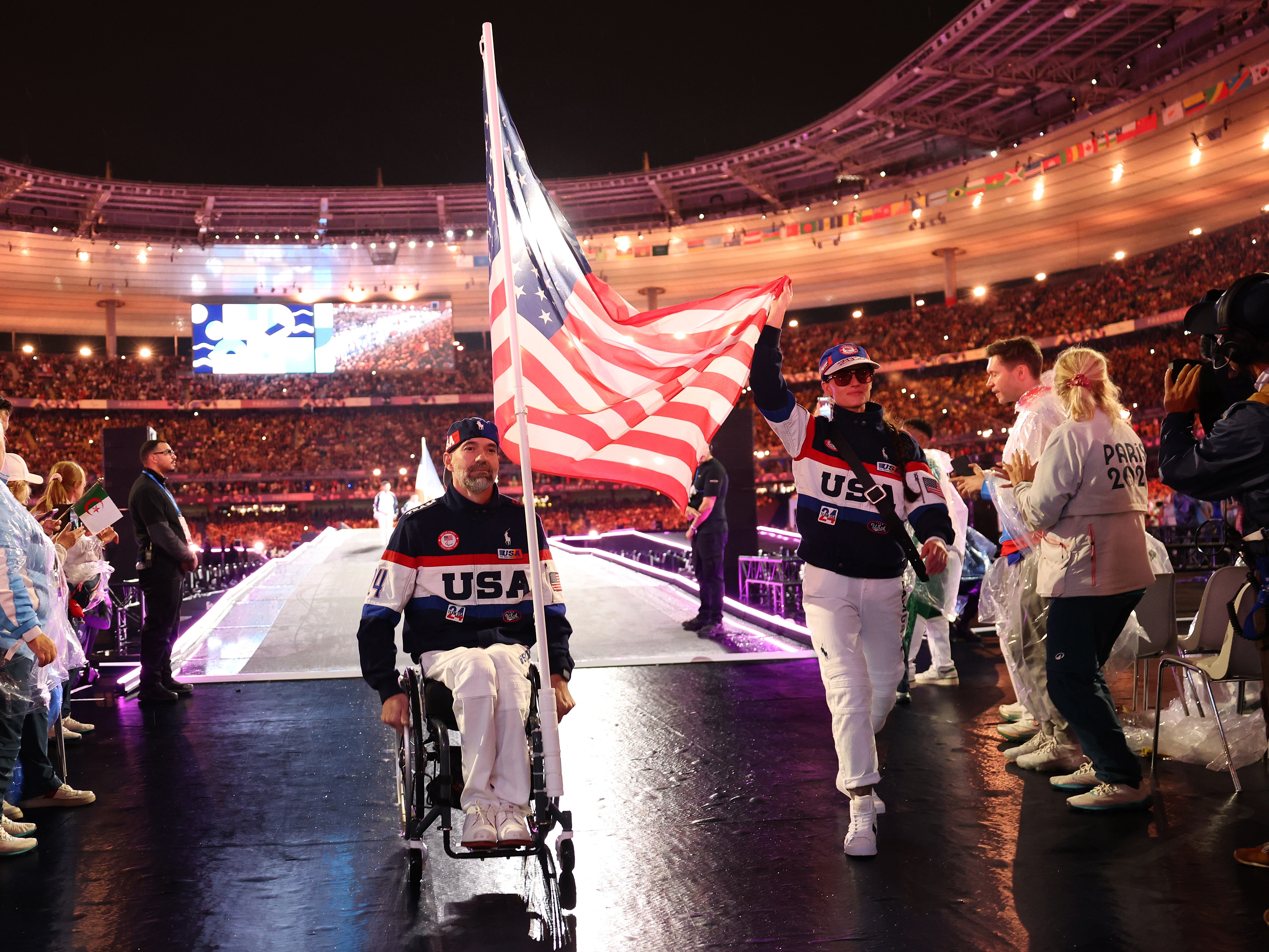 caption: Ellie Marks and Paul Schulte hold Team USA's flag during the closing ceremony of the Summer Paralympic Games at Stade de France on Sunday.