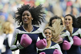 caption: Seattle Seahawks Sea Gals cheerleaders perform during halftime of an NFL football game Sunday, Oct. 29, 2017, in Seattle. The gloves were part of the Seahawks and NFL football's Crucial Catch campaign to support the fight against breast cancer.