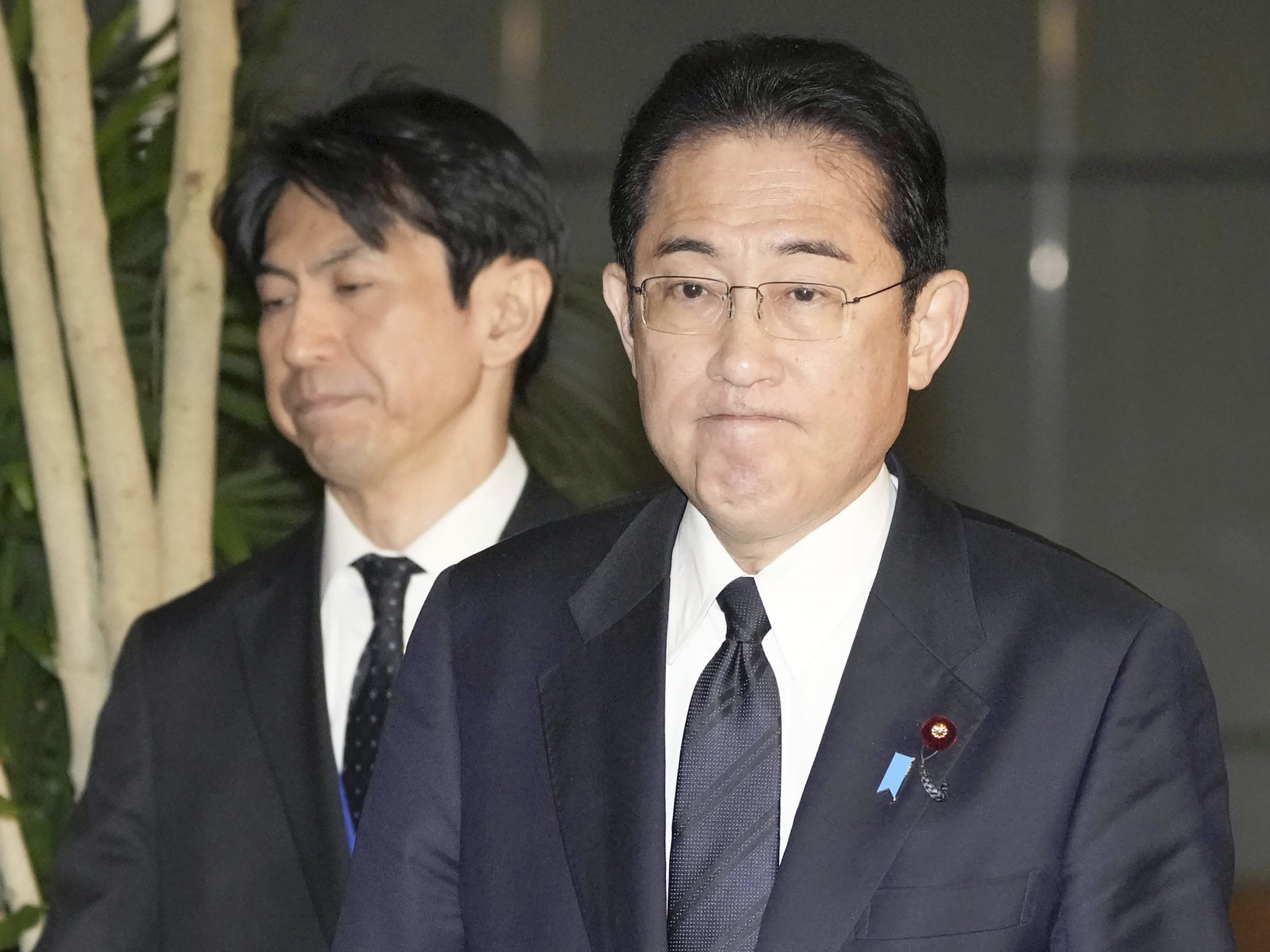 caption: Japan's Prime Minister Fumio Kishida (right) meets with reporters in Tokyo after an army helicopter went missing on Thursday.