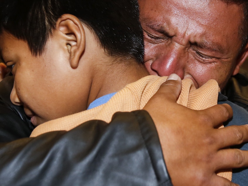 caption: David Xol of Guatemala hugs his son Byron as they were reunited at Los Angeles International Airport in January. The father and son were separated 18 months earlier under the Trump administration's "no tolerance" migration policy.