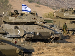 caption: Israeli tanks are stationed near the border with Lebanon on Wednesday. A plurality of Americans say Israel's response to a deadly attack by Hamas has been about right.