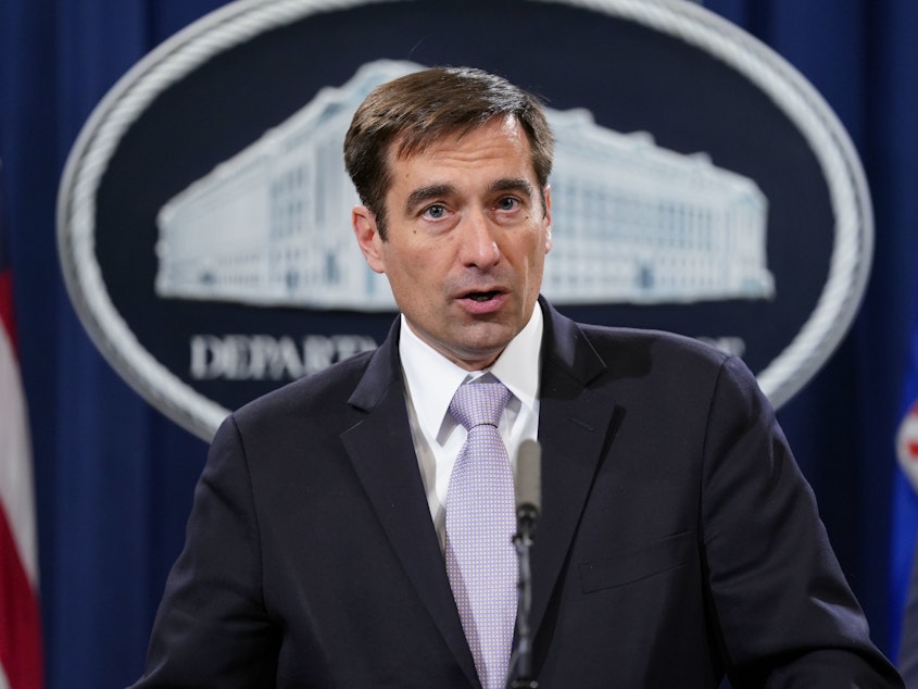 caption: John Demers, assistant attorney general for national security, announces a law enforcement case involving China in November 2018. The Justice Department is prosecuting more alleged cybercrime cases.