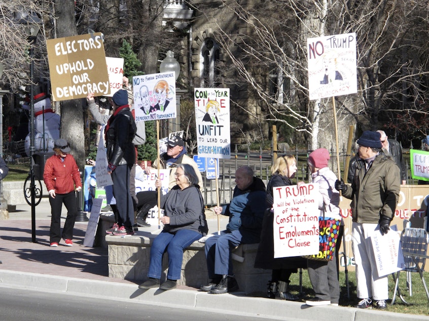 caption: Protesters demonstrate against then President-elect Donald Trump outside the State Capitol building in Carson City, Nev. in Dec. 2016 while Nevada's six Democratic presidential electors inside cast their official Electoral College ballots for Hillary Clinton.