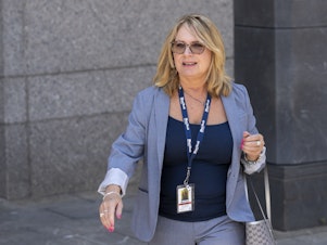 caption: Reporter Julie K. Brown exits federal court following a bail hearing for Jeffrey Epstein in July 2019.